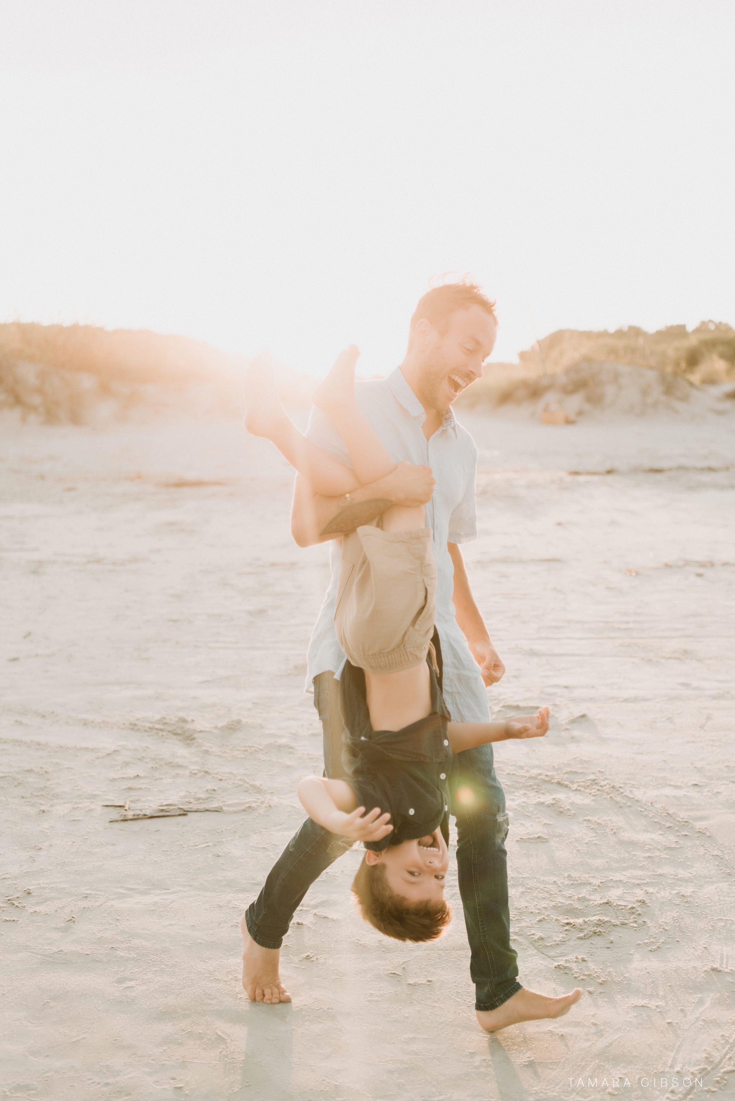 Hallen Father holds son upside down on Saint Simons Island Photo Session. 