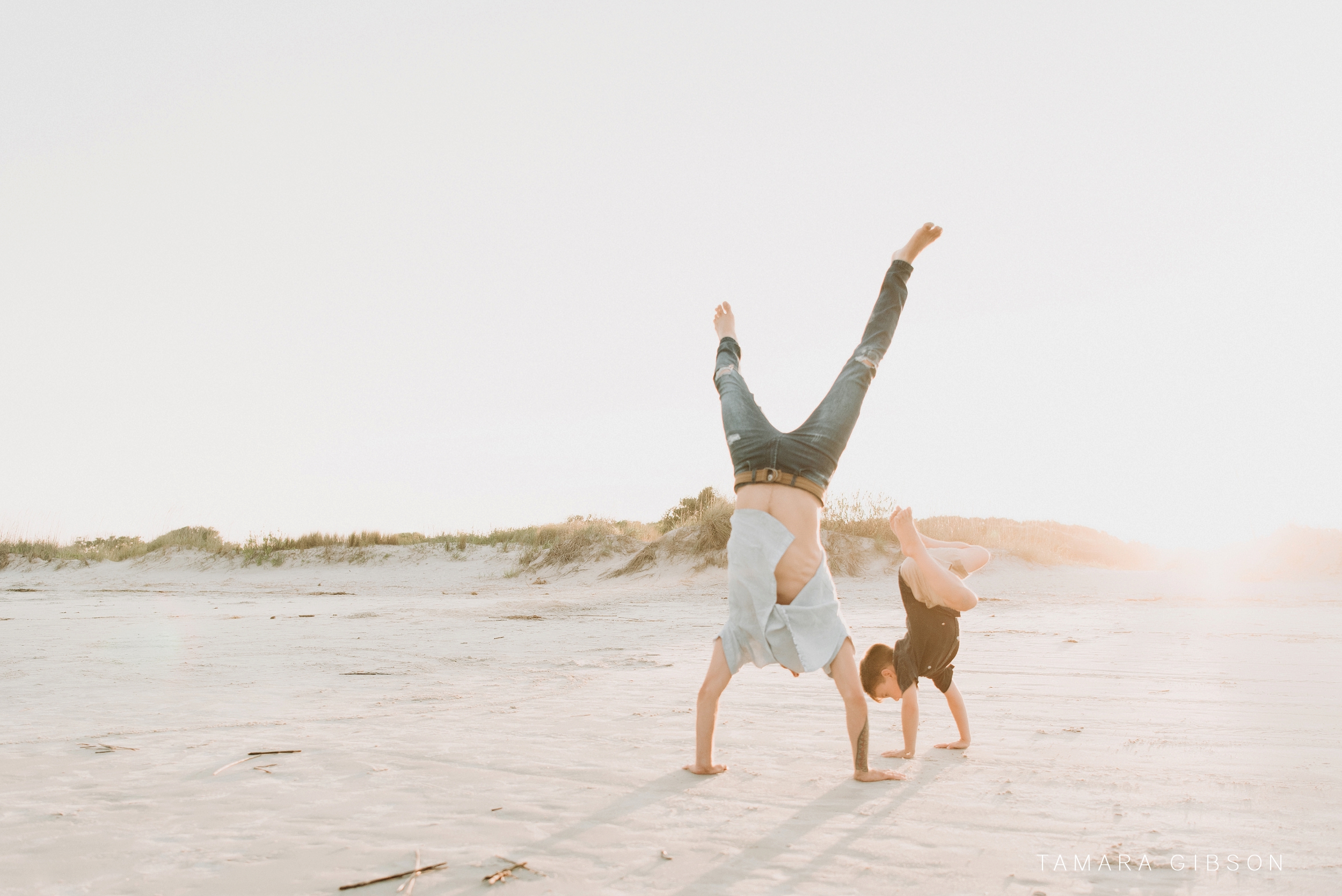 Hallen father and son do handstands at beach at Saint Simons Island photo session